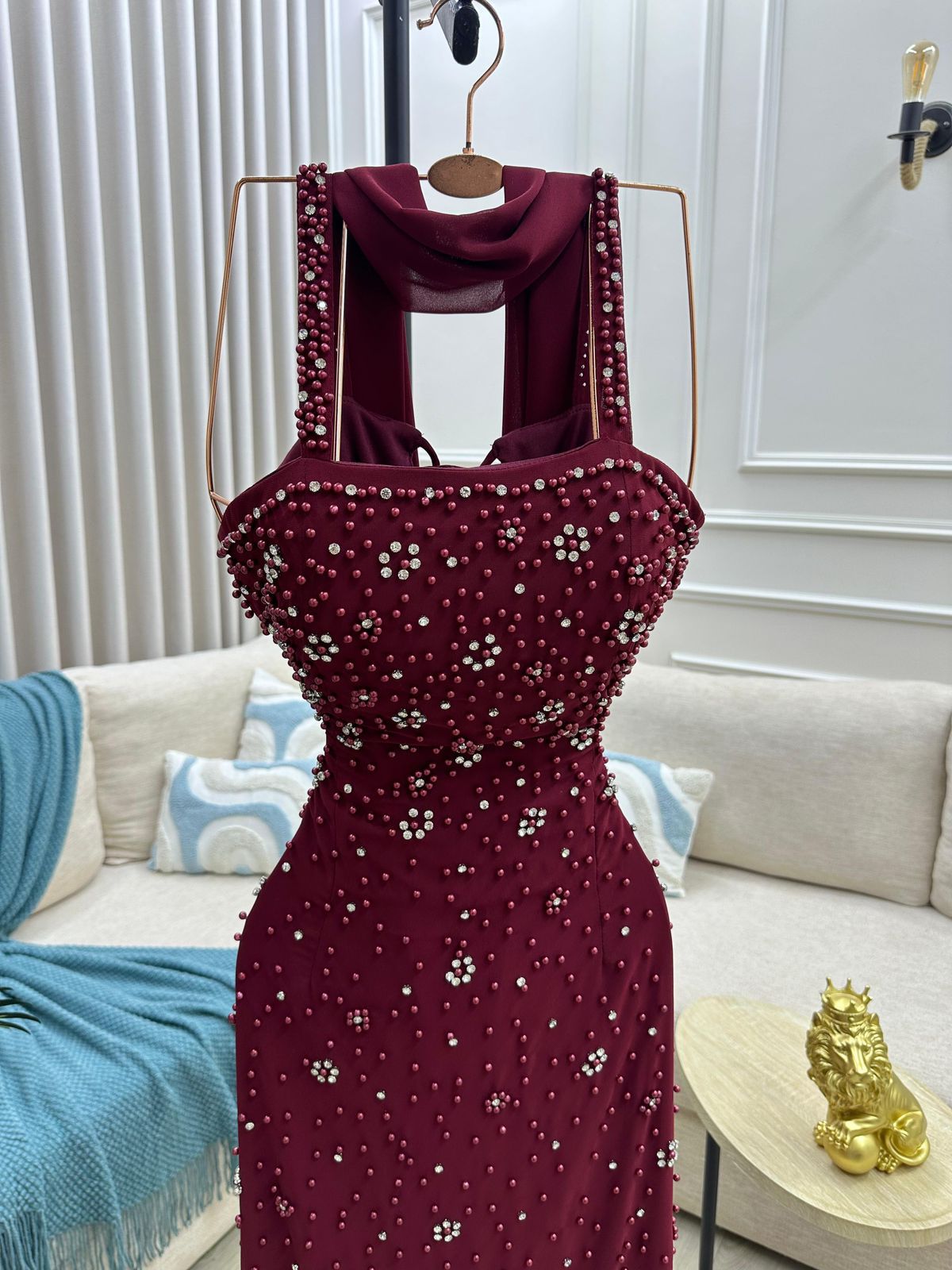فستان سهرة طويل أنيق بلون خمري (مارون) عميق وجذاب. يتميز بتصميم كلاسيكي مع لمسة عصرية من التفاصيل اللامعة.