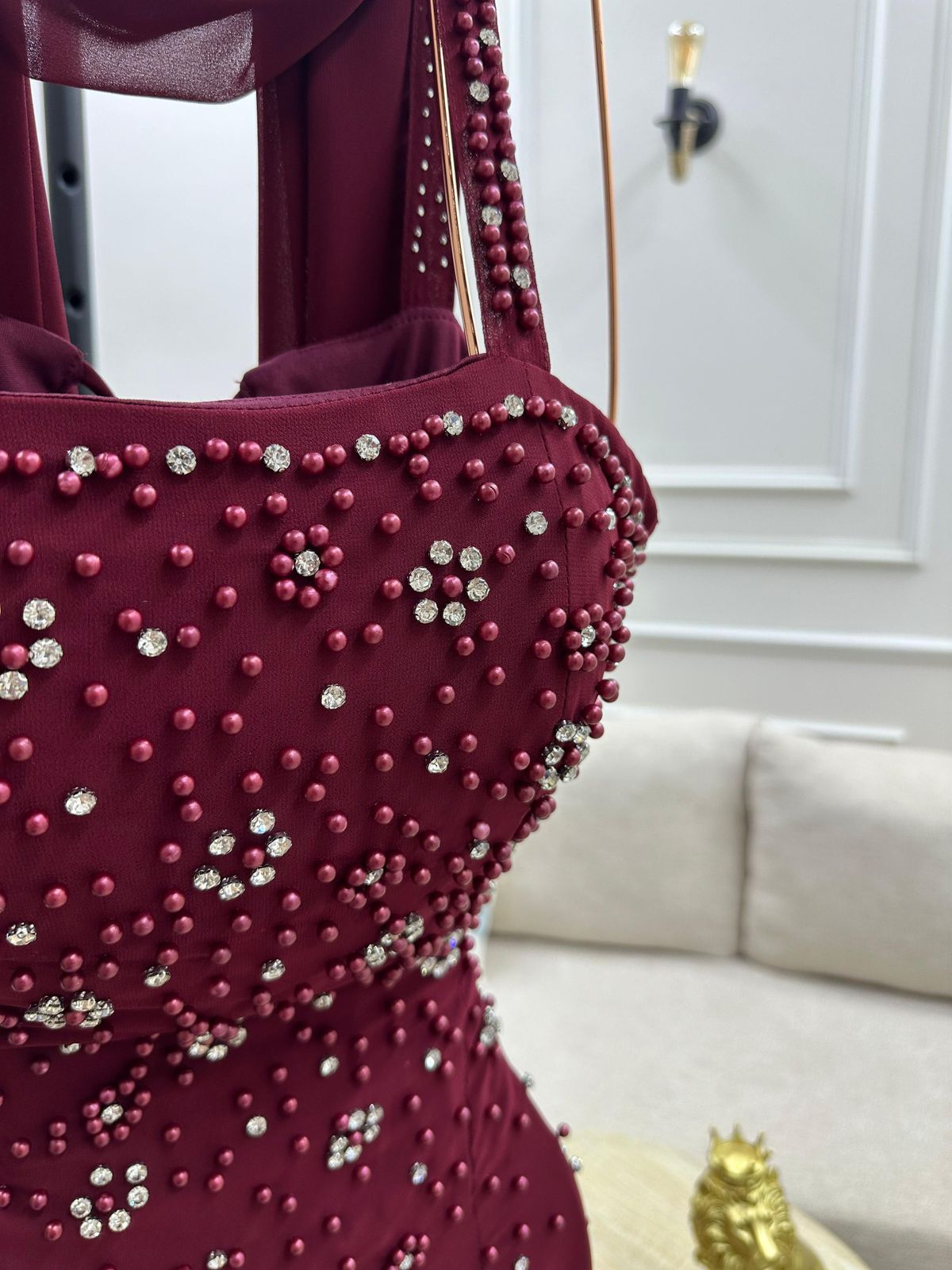 فستان سهرة طويل أنيق بلون خمري (مارون) عميق وجذاب. يتميز بتصميم كلاسيكي مع لمسة عصرية من التفاصيل اللامعة.